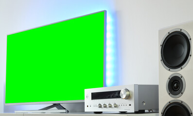 Fototapeta na wymiar Large backlit green screen LED TV with audio receiver in a modern apartment. 