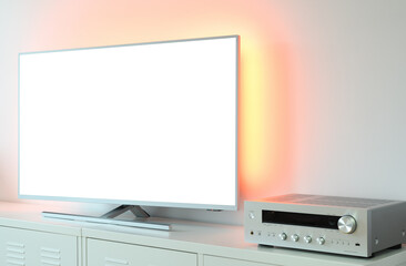 Large backlit LED TV with white screen and audio receiver in a modern apartment. 