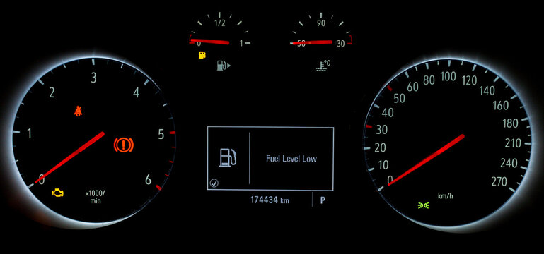 Fuel gauge with warning to indicate low fuel level. Indicator on car dashboard panel. Empty tank of gasoline. Yellow fuel check light. Car cluster with speedometer, tachometer, odometer.