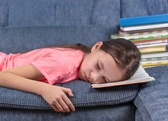 Moe meisje slapen op het boek. Schoolmeisje was haar saaie huiswerk aan het lezen en viel in slaap