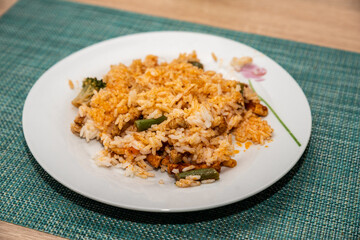 potrawa z ryżu i warzyw na ceramicznym białym talerzu na stole