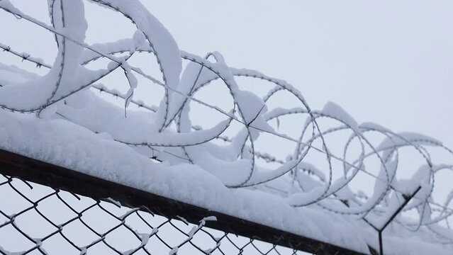 fence with barbed wire covered with snow