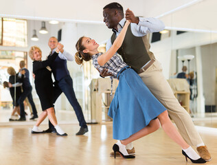 Woman and man dancing waltz in studio