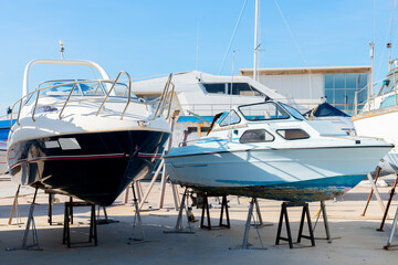Fototapeta premium Boat on the stand in the marine workshop on the beautiful sunny day, a place for maintenance and parking boats