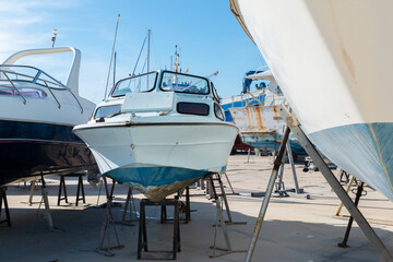 Boat on the stand in the marine workshop on the beautiful sunny day, a place for maintenance and...