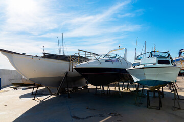 Boat on the stand in the marine workshop on the beautiful sunny day, a place for maintenance and parking  boats