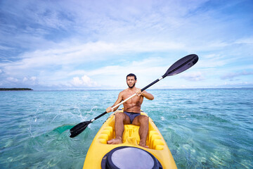 Young man paddling in the sea near the islands. Adventure by kayak.