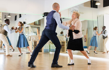 Mature woman dancing swing with young man