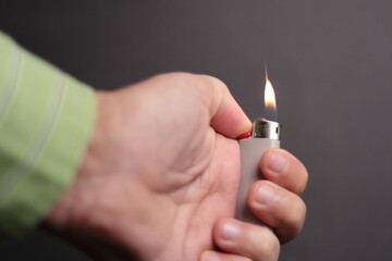 A hand with a lit lighter