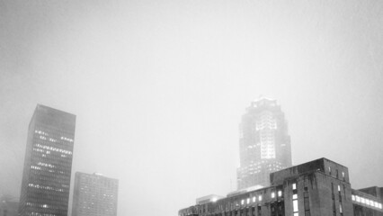 Artistic black and white image of downtown buildings during a snowstorm blizzard.