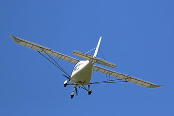 Ultralight airplane flying in a blue sky	