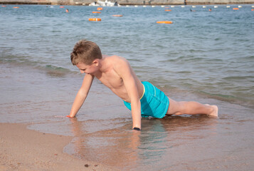 teenage boy goes in for sports on the seashore