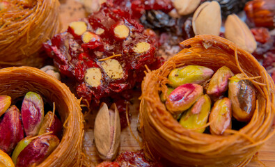 Pistachios in baskets, dried fruits, baklava, Turkish delight from a close distance. Oriental sweets