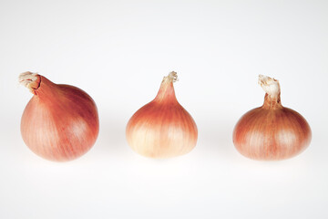 Obraz premium Three onions on a white background