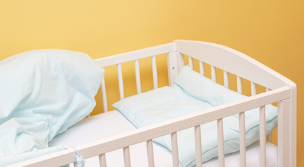 empty baby cot with bedding