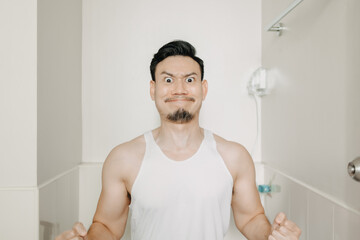 Funny face expression of Asian man try to poop in the toilet.