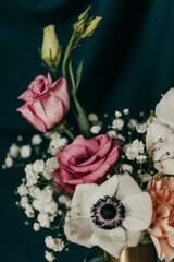 Close up of spring flower arrangement against teal cloth backdrop