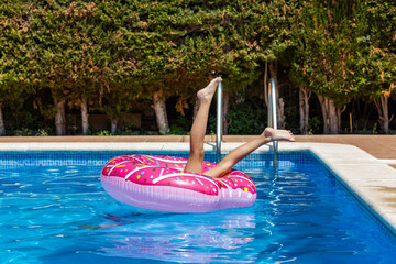 Girl upside down on a float in the pool