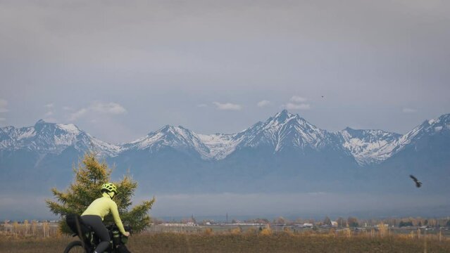 The woman travel on mixed terrain cycle touring with bikepacking. The traveler journey with bicycle bags. Sport tourism bikepacking.
