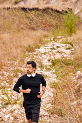 Never stop. Athletic man in black sportswear running in nature. Morning cardio. Caucasian bearded man jogging outdoors. Sport. Workout. Healthy active lifestyle, people exercising