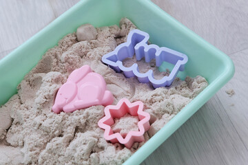 Light kinetic sand and figures. The child sculpts figures from bright details, animals. Educational...