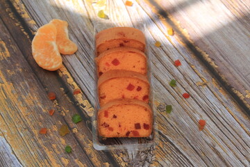 Homemade tutti frutti candied fruit sponge cake on table and colorful background for Christmas