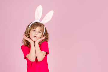 Obraz na płótnie Canvas Surprised cute little girl in Easter bunny ears headband against pink background, copy space