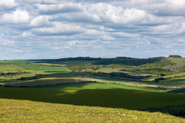 Fototapeta na wymiar Clouds casting shadows over the South Downs hills, on a sunny spring day