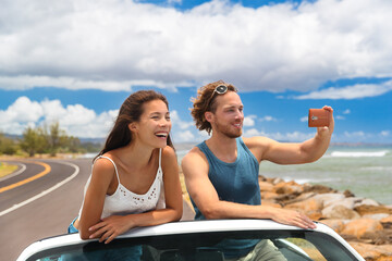 Road trip vacation sports car people taking phone pictures of Hawaii landscape on summer travel...