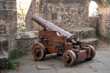 Old cannon in a castle. The battery points from a battlement of the fortress.