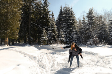 young couple fooling around while on a winter walk near the forest. a general plan of a couple in...