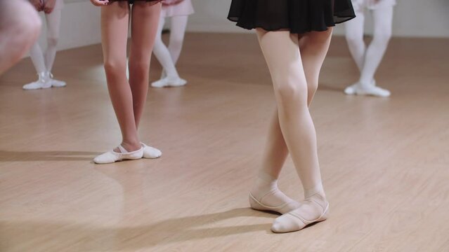 Group of little ballerina girls training in ballet studio