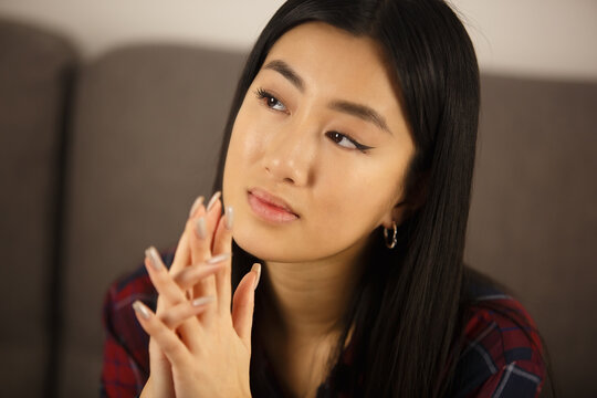Young asian girl portrait. Vietnamese woman thinking about future. Beautiful southeast asian person with long dark hair wearing makeup and long nails