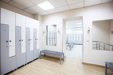 wide frame with a white locker room with wooden cabinets and benches