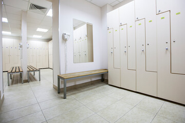wide frame with a white locker room with wooden cabinets and benches