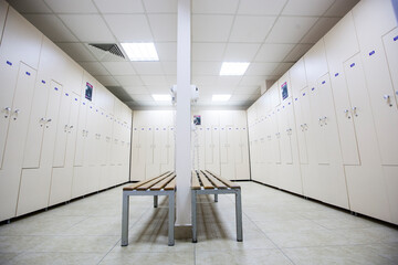 wide frame with a white locker room with wooden cabinets and benches