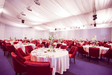 Table at a luxury wedding reception. Beautiful flowers on the table. Serving dishes, glass glasses, waiters work. Health and lifestyle