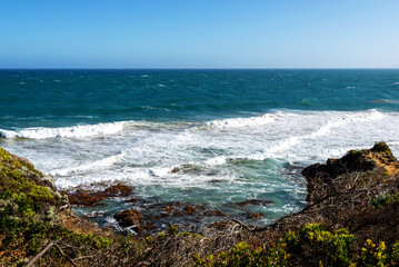Fototapeta na wymiar Aireys Inlet coast with waves and blue sky Great Ocean Road