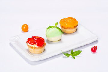 three beautifully colored cakes on the plate and decoration on white background