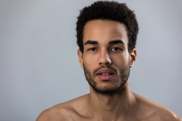 Fototapeta premium Portrait of attractive african american man with stubble and bare shoulders.