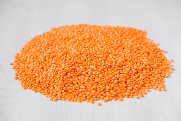 Scattered raw red lentils on a white table