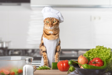 Bengal cat, cutting board and vegetables in the kitchen.
