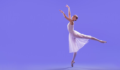 an elegant ballerina in pointe shoes is dancing in a long flying white skirt on a lilac light...