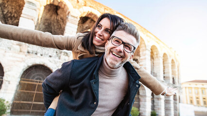Married couple of tourists walking on city street visiting Italy - Senior man and woman enjoying...