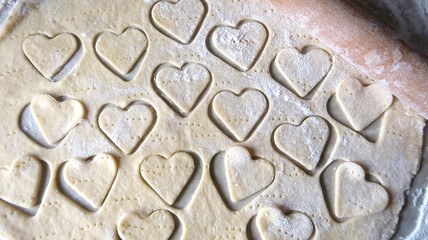 Hearts in soft rolled dough with a wooden rolling pin for valentine's day