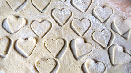 Hearts in soft rolled dough with a wooden rolling pin for valentine's day