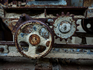 Fototapeta na wymiar engranajes de una máquina vieja y oxidada de una fábrica abandonada