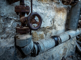 imagen de una válvula y unos tubos en una fábrica abandonada