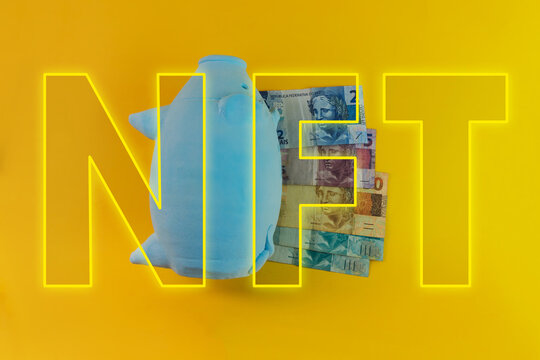 NFT written with piggy bank and Brazilian money isolated on yellow background. NFT Finance image.