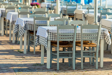 Range of wooden table and white chair for relaxation at restaurant near sea